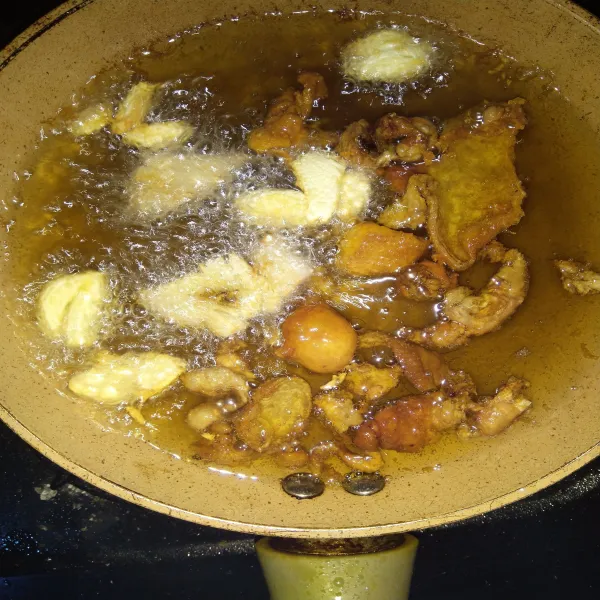 Setelah kulit ayam kering, matikan api. 
Selagi minyak masih panas, masukkan bawang putih dan jahe. 
Biarkan sampai bawang putih dan jahe sampai kering.