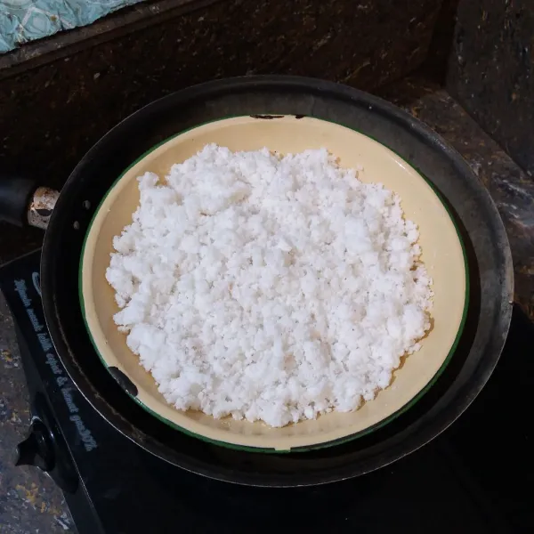 Masukkan kelapa parut dan garam ke dalam wadah, aduk rata, kukus sekitar 15 menit, matikan kompor, sisihkan.