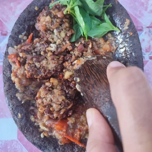 Masukkan tempe dan daun kemangi, penyet dengan ulekan. 
Sajikan.