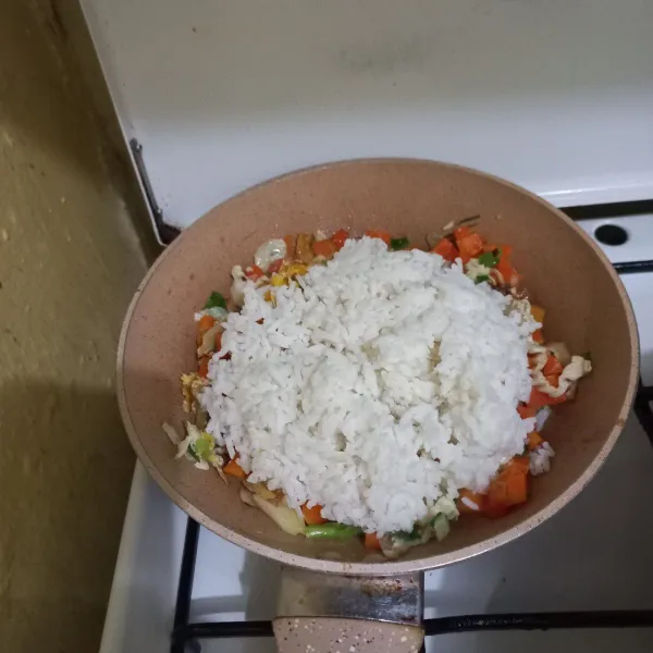 Masukan nasi putih pada wajan, aduk rata.