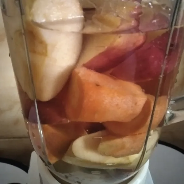 Masukkan wortel dan apel ke dalam blender, tambahkan air dan gula.