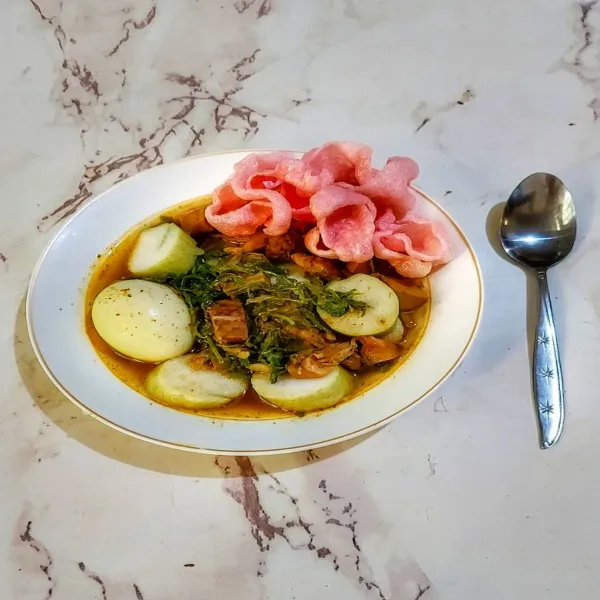 Sajikan sayur dengan potongan lontong dan kerupuk merah.