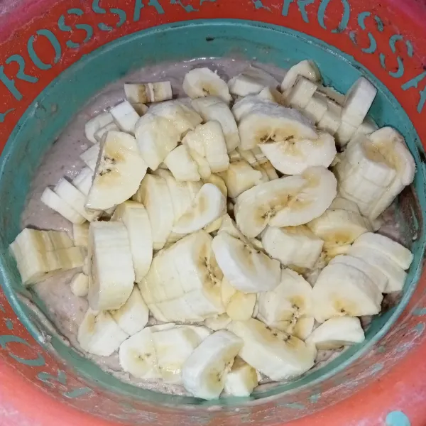 Kupas pisang dan potong-potong, lalu masukkan ke dalam adonan.