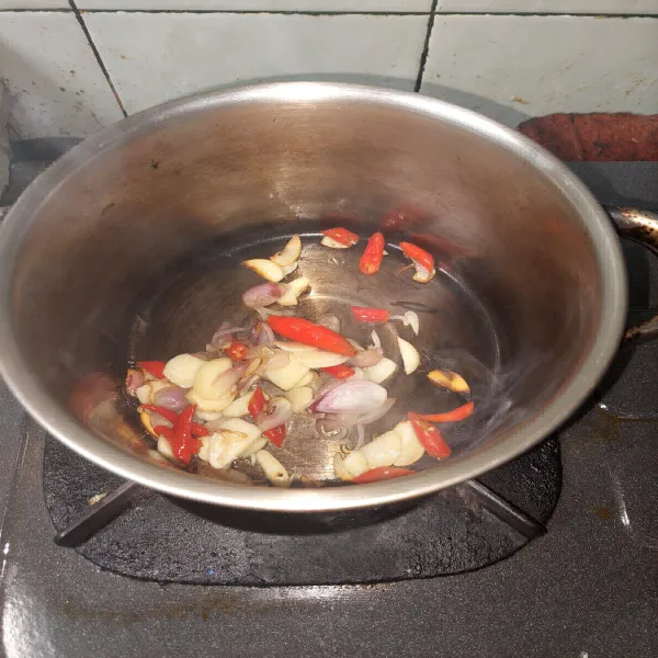 Panaskan minyak, tumis bawang putih dan bawang merah dan cabe merah besar sampai harum.