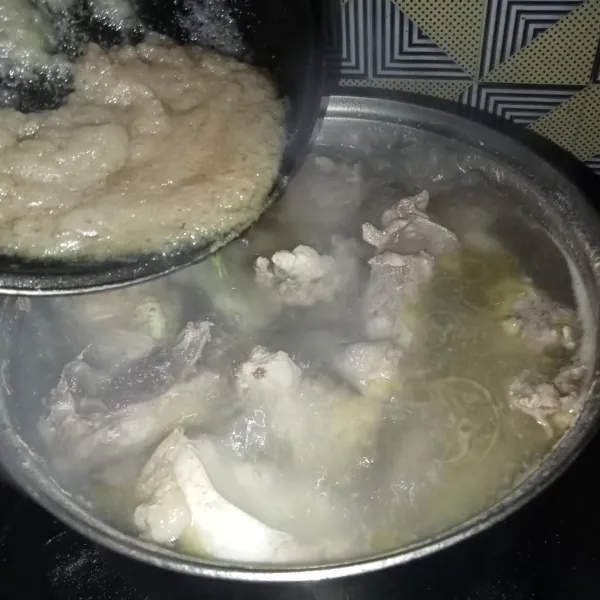 Masukkan bumbu yang sudah ditumis ke dalam rebusan ayam.