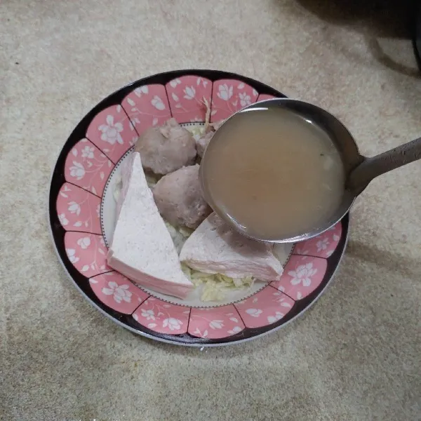 Di mangkok tata soun, sayuran bakso dan tahu kukus.
Lalu siram dengan kuah bakso, sajikan.