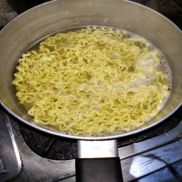 Rebus mie dengan sedikit minyak hingga setengah matang, lalu sisihkan.