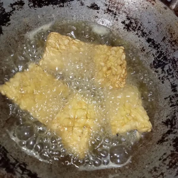 Panaskan minyak goreng lalu masukkan tempe. Goreng hingga kuning keemasan lalu tiriskan.