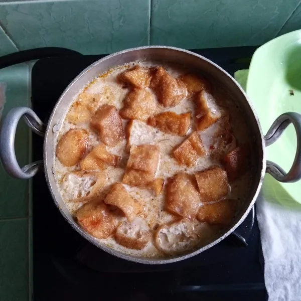 Masukkan ikan tongkol, tahu, air, bumbu lodeh serta santan. 
Beri garam dan gula dan masak hingga mendidih.