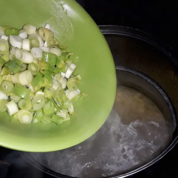 Masukkan bumbu halus ke dalam kuah kaldu. 
Tambahkan juga kaldu bubuk dan daun bawang.