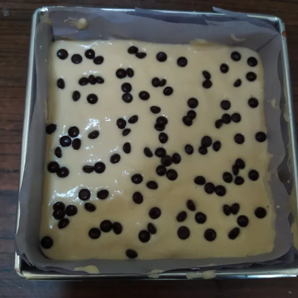 Masukkan ke dalam loyang adonan coklat lalu ratakan, disusul adonan vanila lalu ratakan. 
Hentakan 3 kali lalu taburi atasnya dengan choco chips.