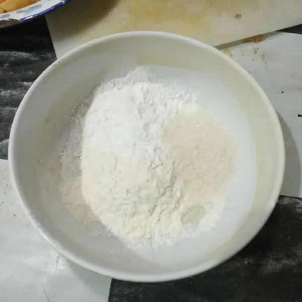 Campurkan tepung terigu, tepung beras, garam, gula pasir, dan vanili, lalu aduk rata.