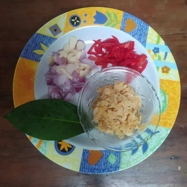 Siapkan irisan bawang merah, bawang putih, cabai, dan daun salam. Untuk udang rebonnya, letakkan di saringan kelapa. Lalu cuci bersih di air mengalir.