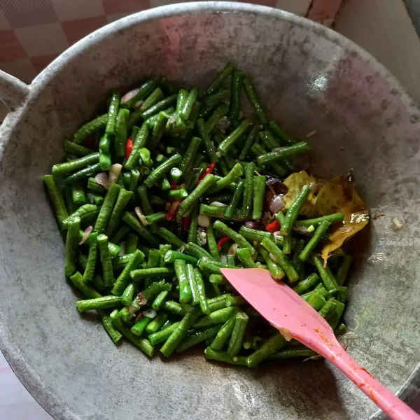 Masukkan kacang panjang dan oseng-oseng hingga layu.