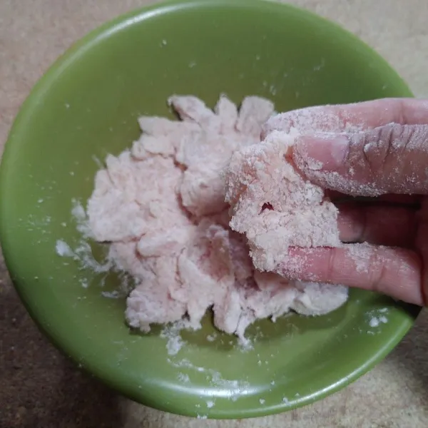 Masukkan potongan daging ayam ke dalam campuran tepung sambil ditekan-tekan agar menempel sempurna.