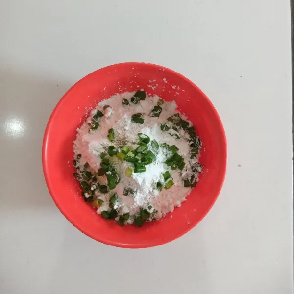Masukkan ke dalam mangkuk tepung tapioka, daun bawang, bawang putih, garam, kaldu jamur dan merica, aduk rata.