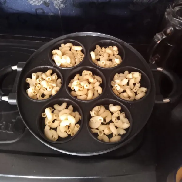 Masukkan secukupnya macaroni ke dalam masing-masing lubang snackmaker.