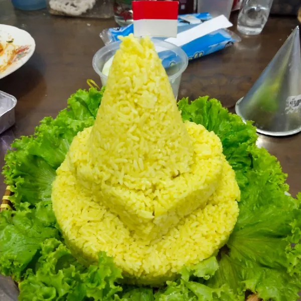 Setelah nasi kuning matang tata dengan selada lalu cetak menyerupai tumpeng.