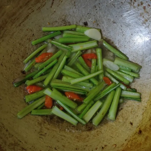 Masukkan air, kaldu bubuk, lada bubuk, dan gula pasir, lalu aduk rata. Biarkan hingga mendidih dan cicipi rasanya. Masak hingga batang layu.