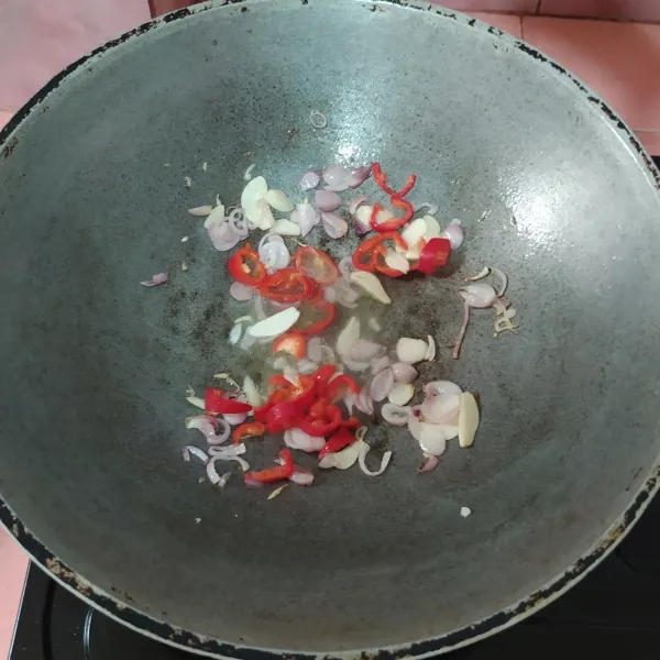 Tumis bawang merah dan bawang putih hingga harum. Kemudian masukkan cabai merah dan tumis sampai layu.