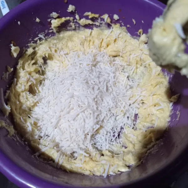 Mixer dengan speed rendah margarin, butter, gula halus, dan kuning telur sampai creamy. Kemudian masukkan keju parut dan aduk rata.