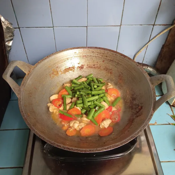 Masukkan wortel dan masak hingga setengah matang, lalu tambahkan buncis dan aduk rata.