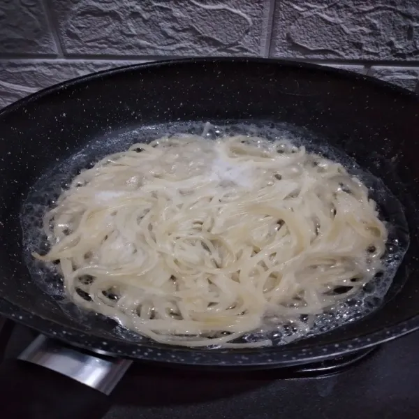 Didihkan air bersama spaghetti, masak hingga spaghetti al dente. Kemudian siram dengan air dingin, lalu tiriskan. Beri sedikit minyak supaya tidak menempel.