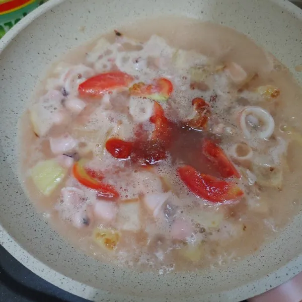 Tuang sedikit air,masukkan irisan tomat dan saus tomat. Lalu bumbui dengan garam, gula, dan kaldu bubuk. Aduk hingga merata.