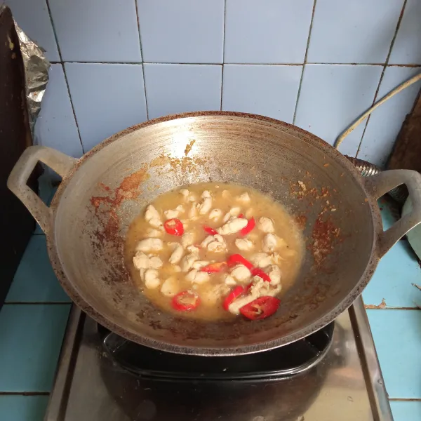 Tambahkan cabai merah, lalu tuang air dan masak hingga mendidih.