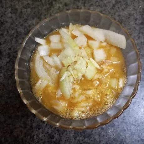 Kocok lepas telur beserta bawang putih cincang, irisan bawang bombay, garam, kaldu jamur, dan merica bubuk.