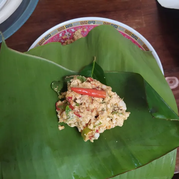 Bungkus pepes dengan daun pisang, kemudian beri daun salam dan cabai rawit.