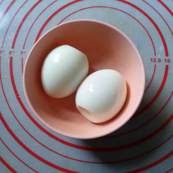 Rebus telur dengan tingkat kematangan sempurna. Lupas cangkangnya.