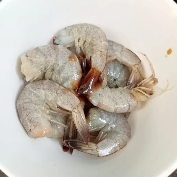 Buang kepala udang, lalu cuci bersih udang. Rendam udang dengan saus tiram selama 10 menit.