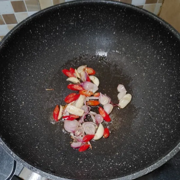 Panaskan wajan, kemudian tumis hingga harum bawang merah, bawang putih, dan cabai rawit.