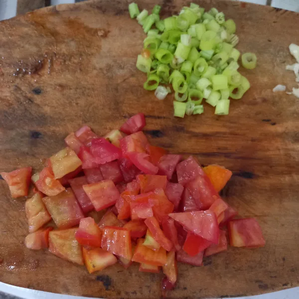 Potong dadu tomat dan iris daun bawang.