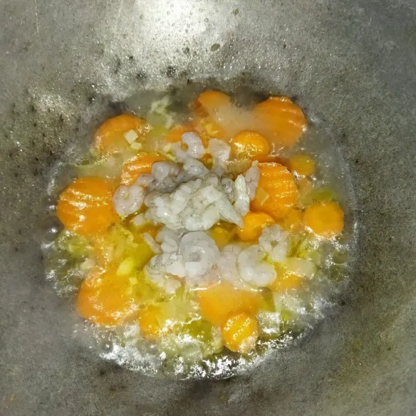 Masukkan wortel dan air, masak hingga wortel setengah matang, lalu masukkan udang, aduk rata.