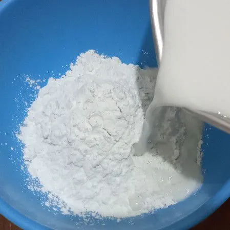 Tuang santan ke tepung sedikit demi sedikit sambil diaduk.