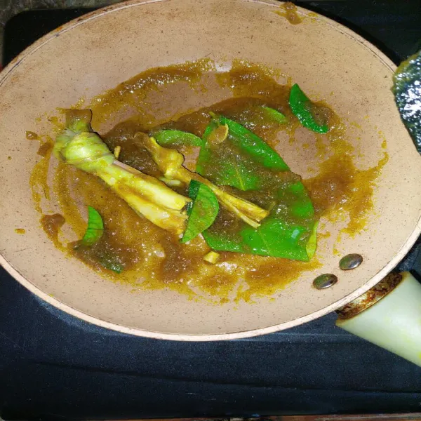 Panaskan sedikit minyak goreng, tumis bumbu dasar kuning dan tambahkan serai, daun jeruk dan daun salam. Tumis sampai bumbu harum.