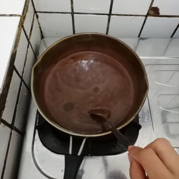 Masak adonan puding sambil terus diaduk hingga mendidih. Matikan api dan tunggu uap panas hilang.