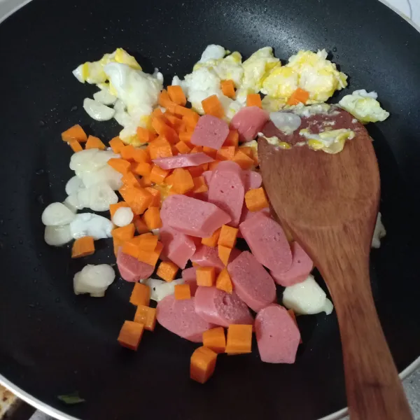 Masukkan wortel dan sosis, tumis sampai berubah warna.