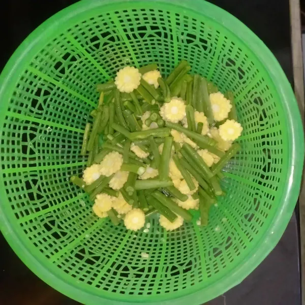 Potong kacang panjang dan baby corn. Cuci bersih, tiriskan.