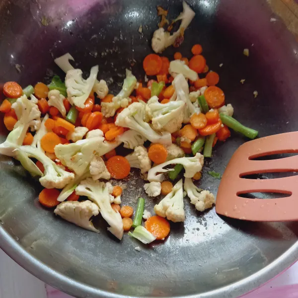 Masukkan sayuran dan oseng-oseng sampai layu.