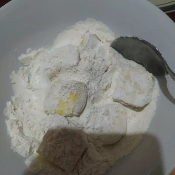 Gulingkan potongan tahu ke tepung bumbu kering.