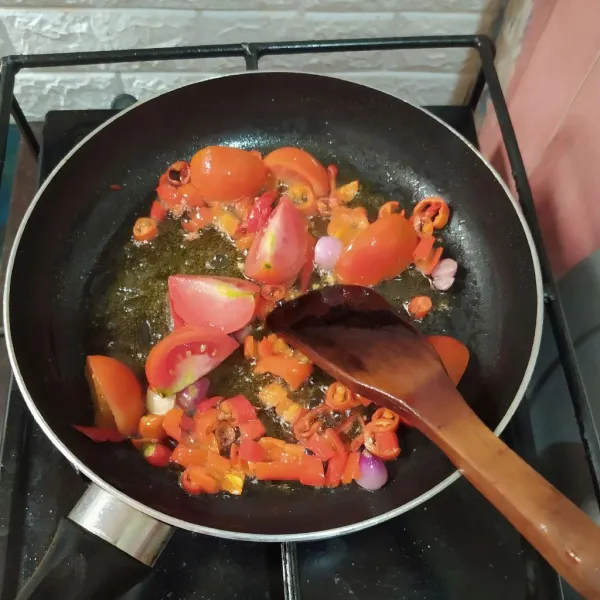 Panaskan minyak lalu goreng bawang merah, bawang putih, cabe dan tomat.