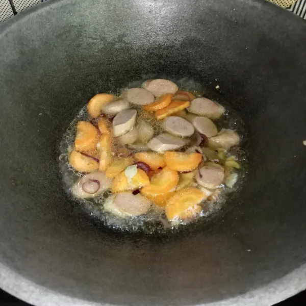 Masukkan wortel dan sosis, aduk rata. 
Kemudian tuang air dan bumbui dengan garam, lada bubuk, gula pasir dan kaldu jamur.