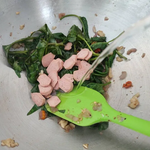 Masukkan kangkung, tumis hingga layu. 
Tambahkan sosis dan air.