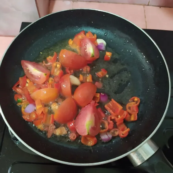 Panaskan minyak lalu goreng bawang merah, bawang putih, cabe dan tomat.