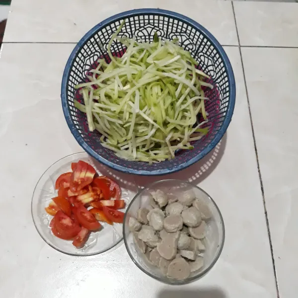 Bersihkan labu siam, lalu iris halus/serut. Kemudian cuci tomat, lalu potong-potong dan iris-iris bakso.