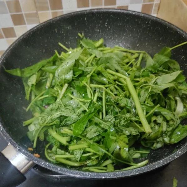 Masukkan sayur kangkung dan aduk rata.