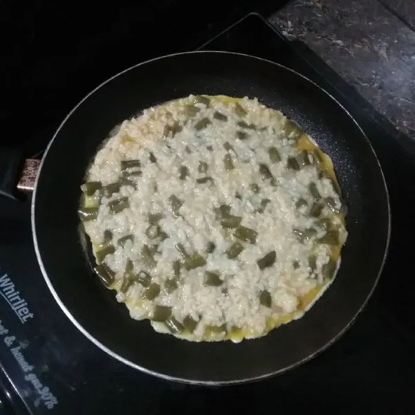 Panaskan teflon, tuang adonan omelet, ratakan, diamkan hingga bagian bawah berwarna kecokelatan.